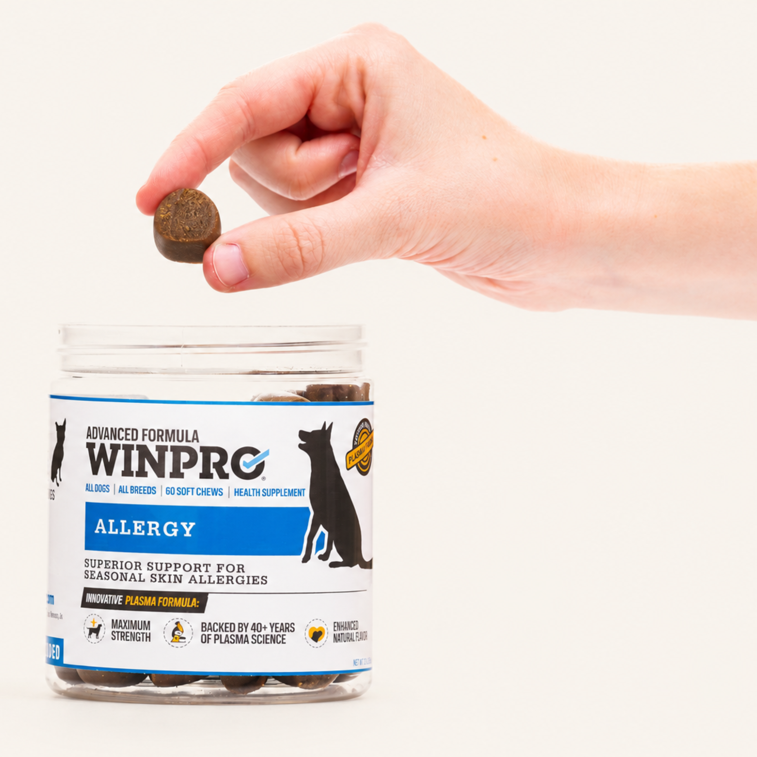 A hand giving a WINPRO Allergy soft chew above the jar